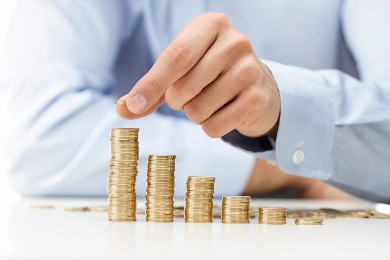 A person is stacking coins on top of each other.