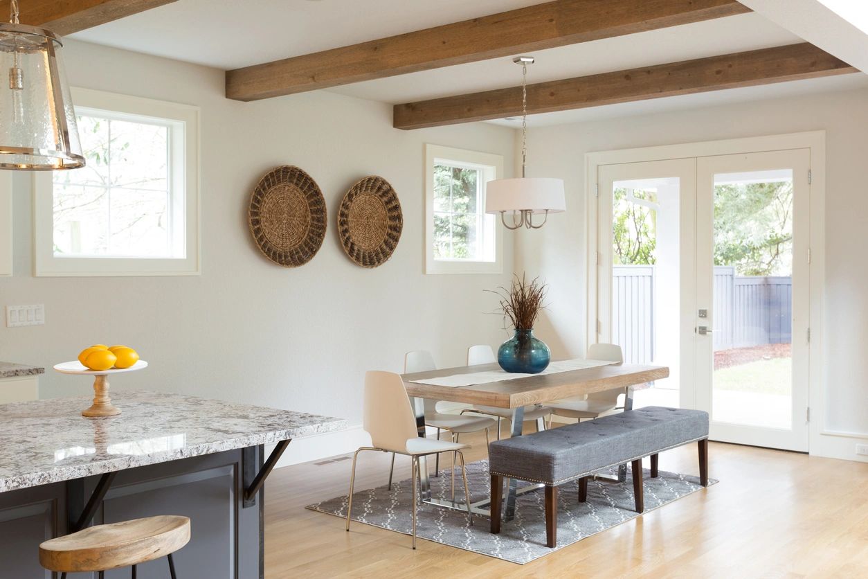 A dining room with a table and chairs, two baskets on the wall.