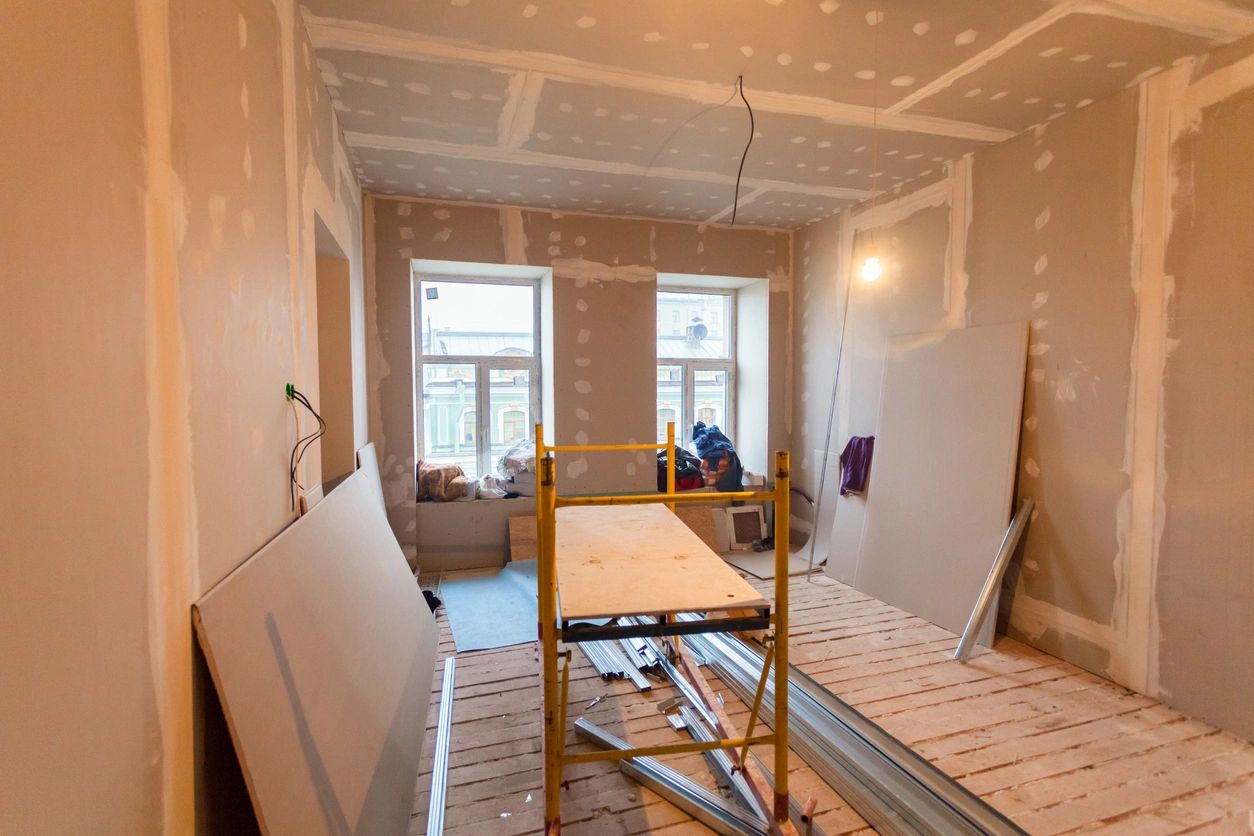 A room being remodeled with a ladder in the middle.