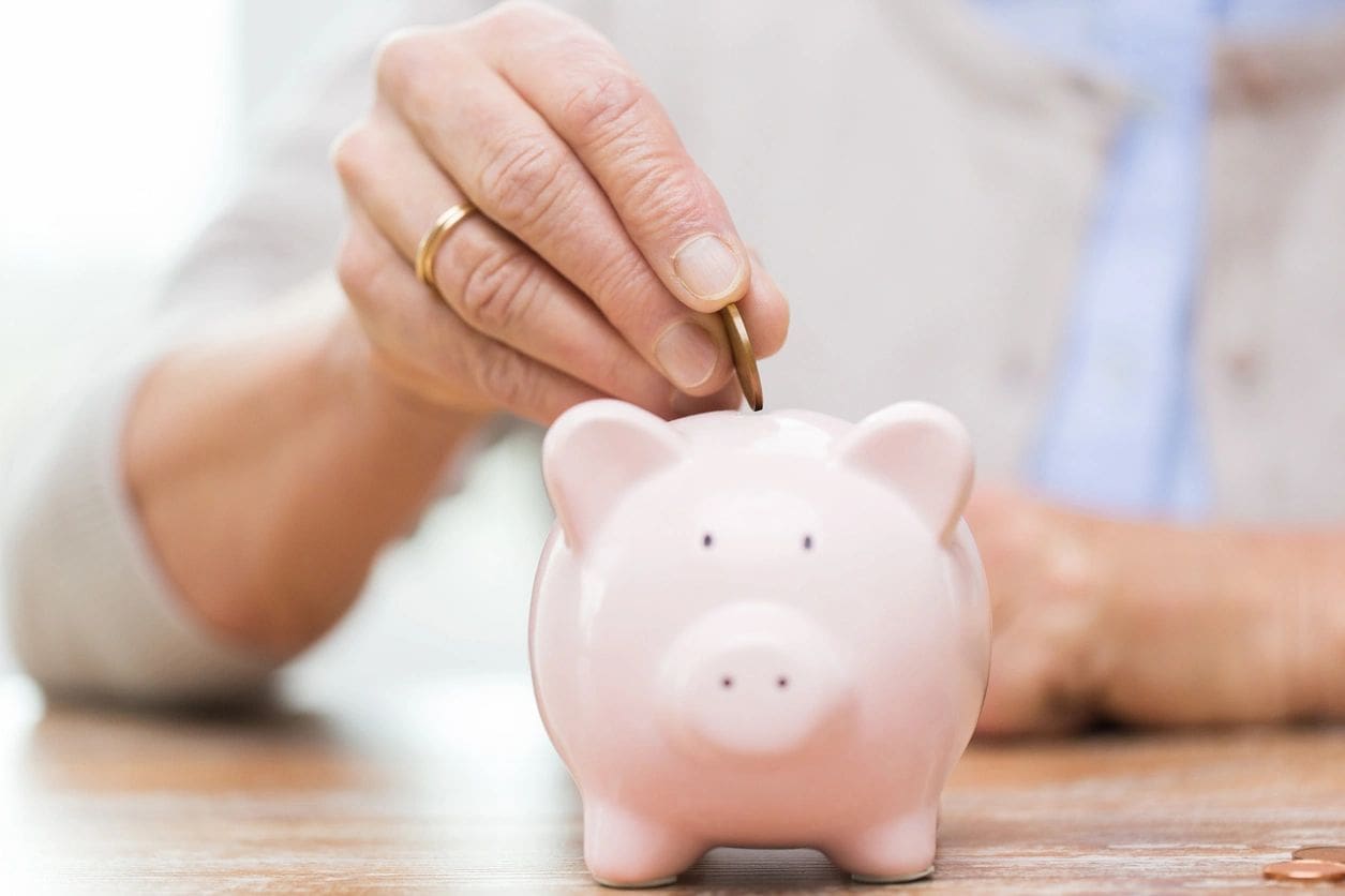 A person putting money into a piggy bank